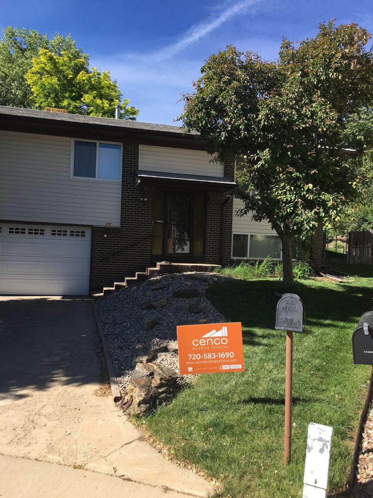 Cenco Building Services yard sign in front of a brick split-level home after a roofing project